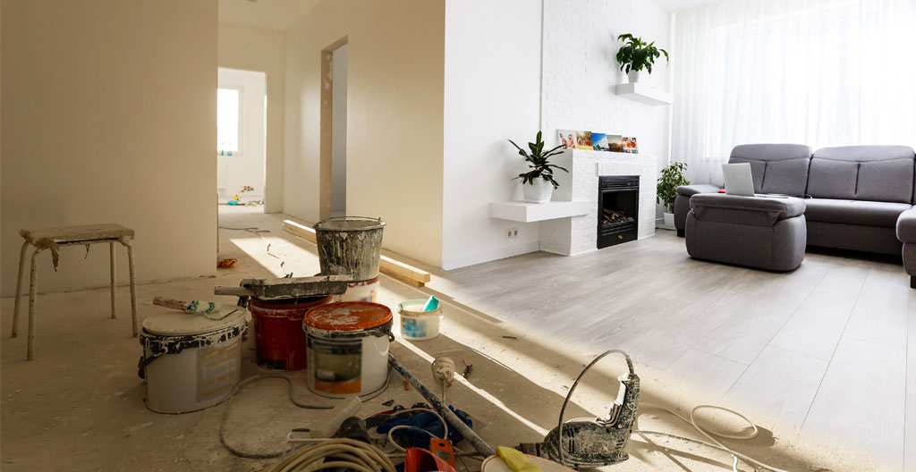 Intérieur lumineux d'un appartement vide en cours de rénovation avec échelle et bâches au sol